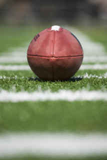 Close up of football on yard line marker.