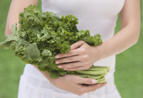 Woman holding fresh kale.
