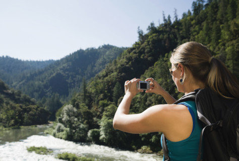 Hiker photographing river scene. Date : 2008