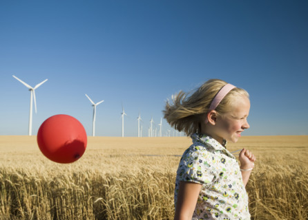 Girl holding balloon on wind farm. Date : 2008
