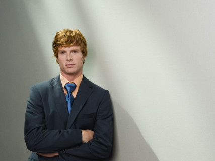 Confident businessman leaning against wall. Date : 2008