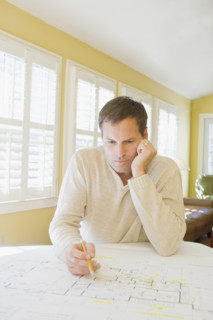 Man reviewing house blueprints. Date : 2008