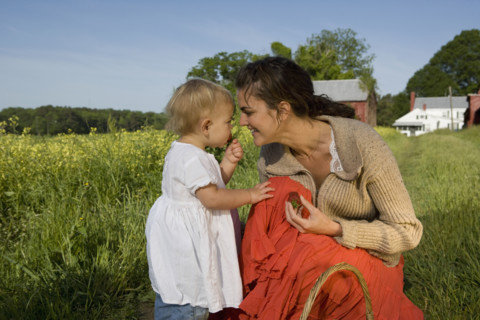 Mother and baby daughter picking strawberries. Date : 2008