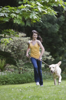 Girl running dog in park. Date : 2008