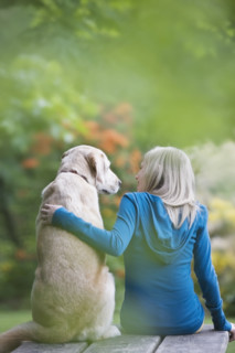 Girl and dog sitting together on picnic table. Date : 2008