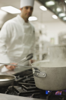 Chef and steaming pot on stove. Date : 2008