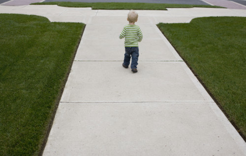 Baby boy walking on sidewalk. Date : 2008