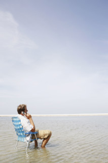 Man talking on cell phone in middle of water. Date : 2008