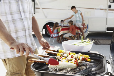 Man grilling dinner for family on beach. Date : 2008