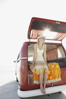Young woman sitting in van on beach. Date : 2008