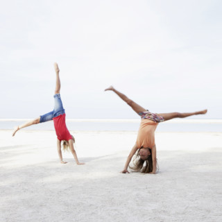 Girls doing cartwheels on beach. Date : 2008