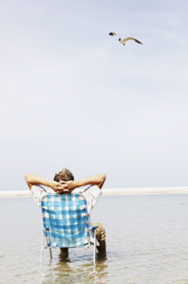 Man relaxing in lounge chair in middle of water. Date : 2008