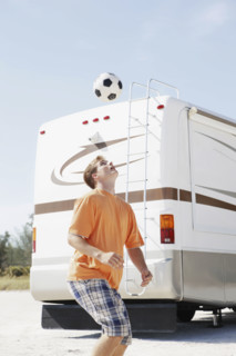 Young man playing with soccer ball on beach. Date : 2008