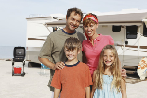 Family posing by motor home on beach. Date : 2008