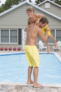 Father throwing son into swimming pool. Date : 2008