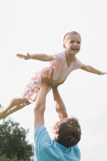 Father lifting daughter in backyard. Date : 2008