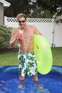 Man standing in inflatable swimming pool. Date : 2008