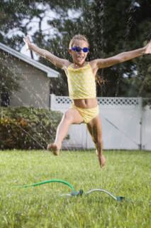 Girl running through sprinkler. Date : 2008