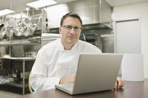 Chef working on laptop in kitchen. Date : 2008