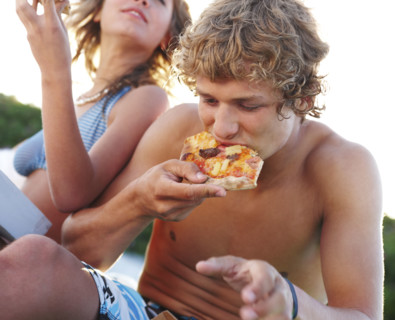 Young couple eating pizza at beach. Date : 2008