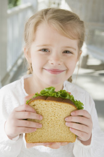 Girl eating sandwich on porch. Date : 2008