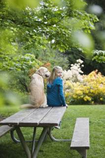 Girl and dog sitting on park bench. Date : 2008