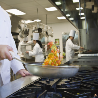 Chef tossing food in skillet. Date : 2008
