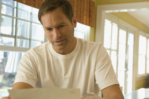Man reading letter at home. Date : 2008