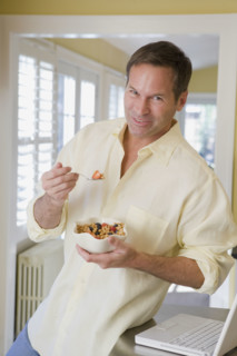 Man eating cereal in kitchen. Date : 2008