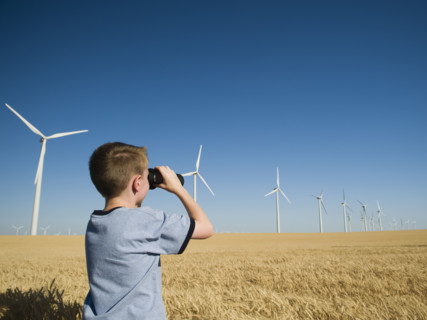 Boy on wind farm looking through binoculars. Date : 2008
