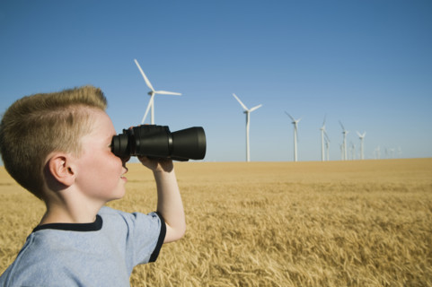 Boy on wind farm looking through binoculars. Date : 2008