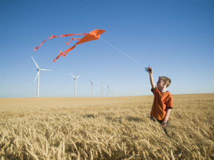 Boy running with kite on wind farm. Date : 2008