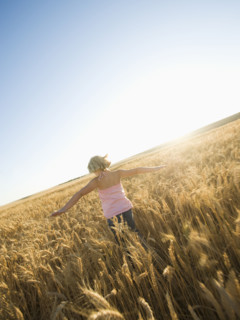 Girl running through tall wheat field. Date : 2008