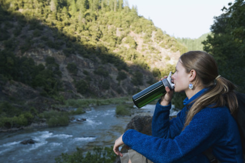 Young woman drinking water on river overlook. Date : 2008