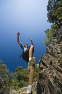 Hiker jumping down rocky trail. Date : 2008