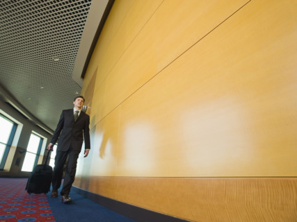Businessman pulling suitcase in office corridor. Date : 2008
