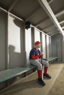 Serious baseball player sitting in dugout. Date : 2008