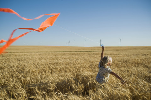 Girl running with kite on wind farm. Date : 2008