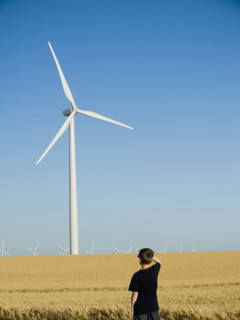 Boy looking at windmill on wind farm. Date : 2008