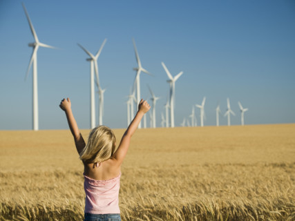 Girl with arms raised on wind farm. Date : 2008