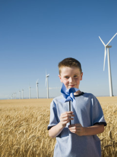 Boy holding pinwheel on wind farm. Date : 2008