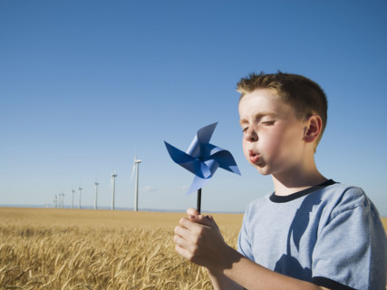 Boy holding pinwheel on wind farm. Date : 2008