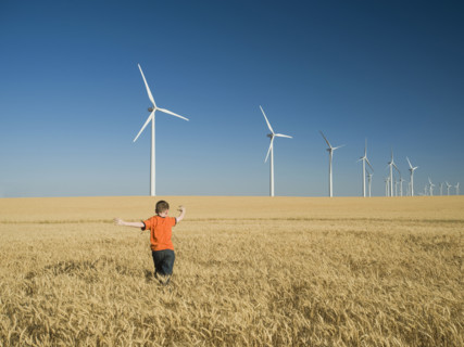 Boy running through field on wind farm. Date : 2008