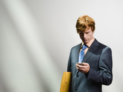 Businessman looking at cell phone. Date : 2008