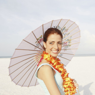 Young woman posing on beach with lei and umbrella. Date : 2008