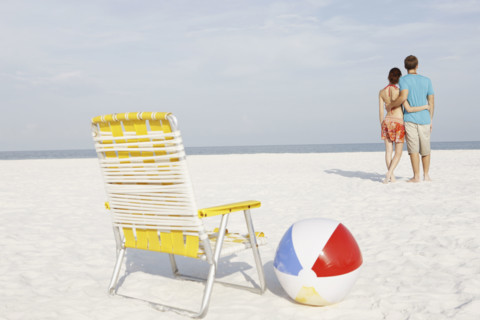 Young couple, chair and ball on beach. Date : 2008