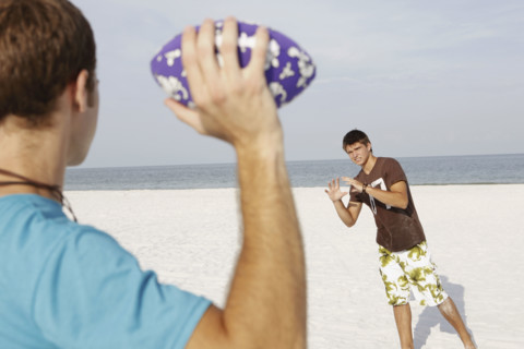 Friend playing football on beach. Date : 2008