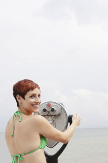 Woman looking through coin-operated binoculars. Date : 2008