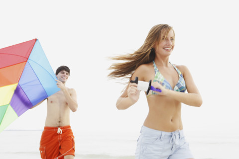 Friends flying kite on beach. Date : 2008