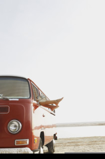Feet sticking out of van window on beach. Date : 2008